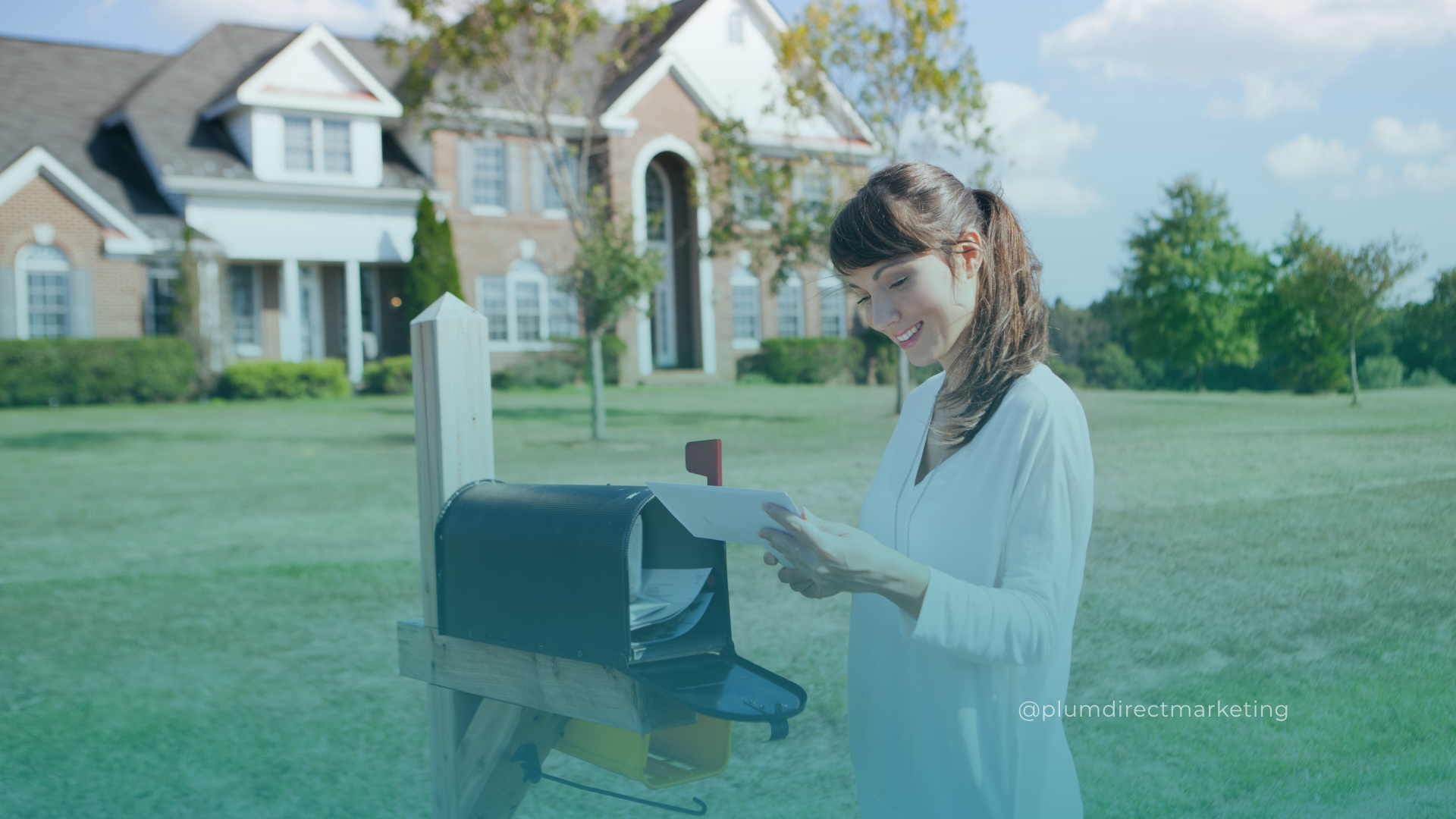 Woman smiling while checking direct mail in 2025 suburban mailbox — direct mail marketing ideas in action.