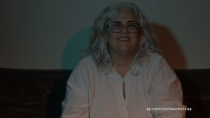 Confident middle-aged woman sitting and smiling, representing the straightforward and authentic communication style preferred by Generation X in direct mail marketing