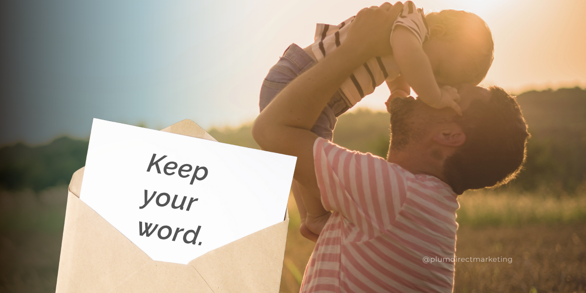 Father lifting baby with a card that says: “Keep your word.” A symbol of integrity and trust in legacy-driven financial marketing strategies.